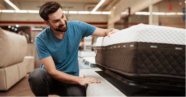 Two young ladies talking one holding a book another with box in a collge dorm
